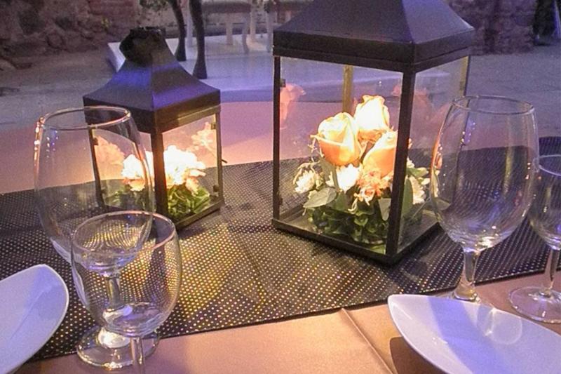 Linternas de metal con flores y vela sobre la mesa